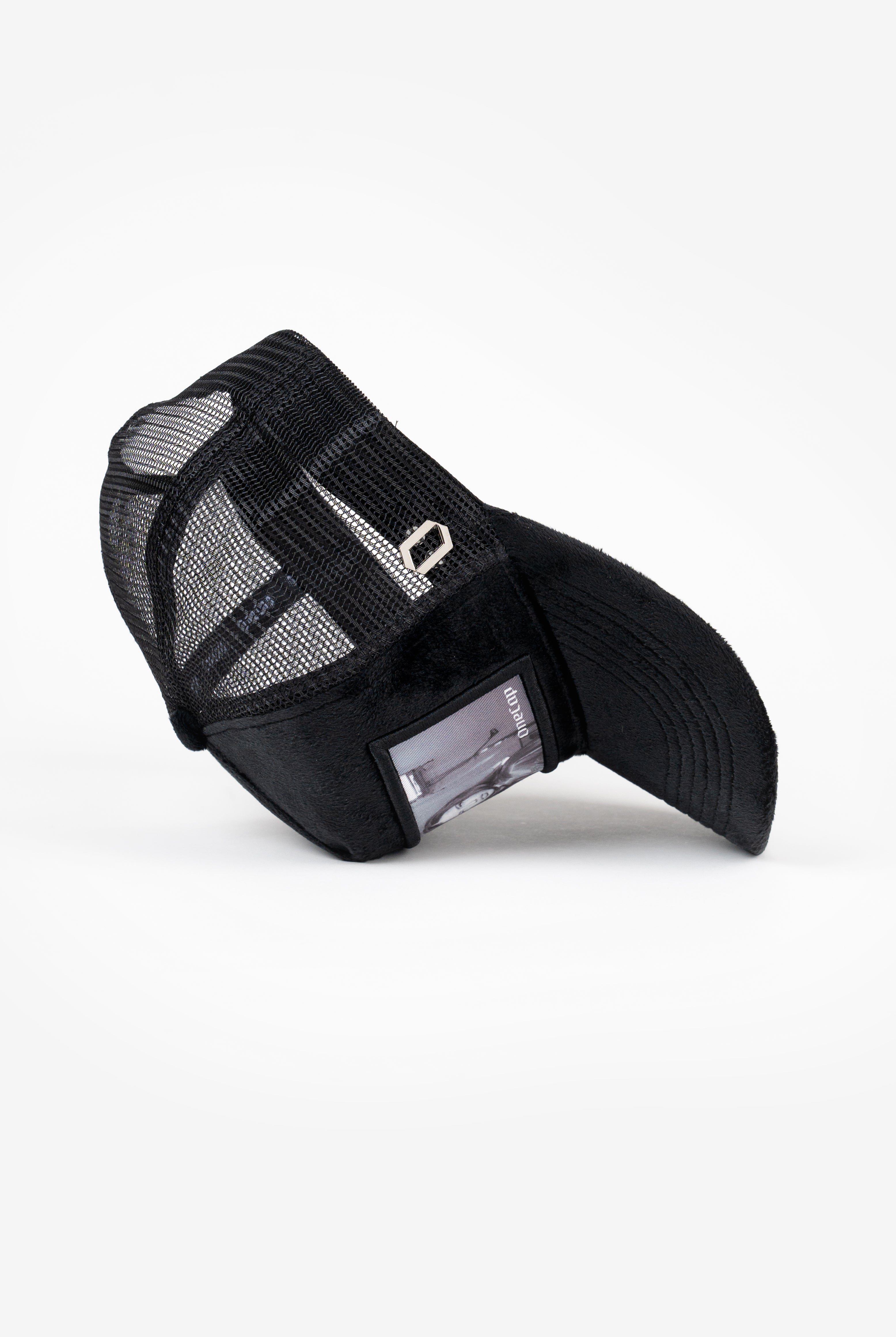 Black mesh snapback cap with transparent pocket on side and curved brim.