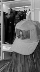 Person wearing a cap featuring an image of Adriana Lima in a stylish wardrobe room.